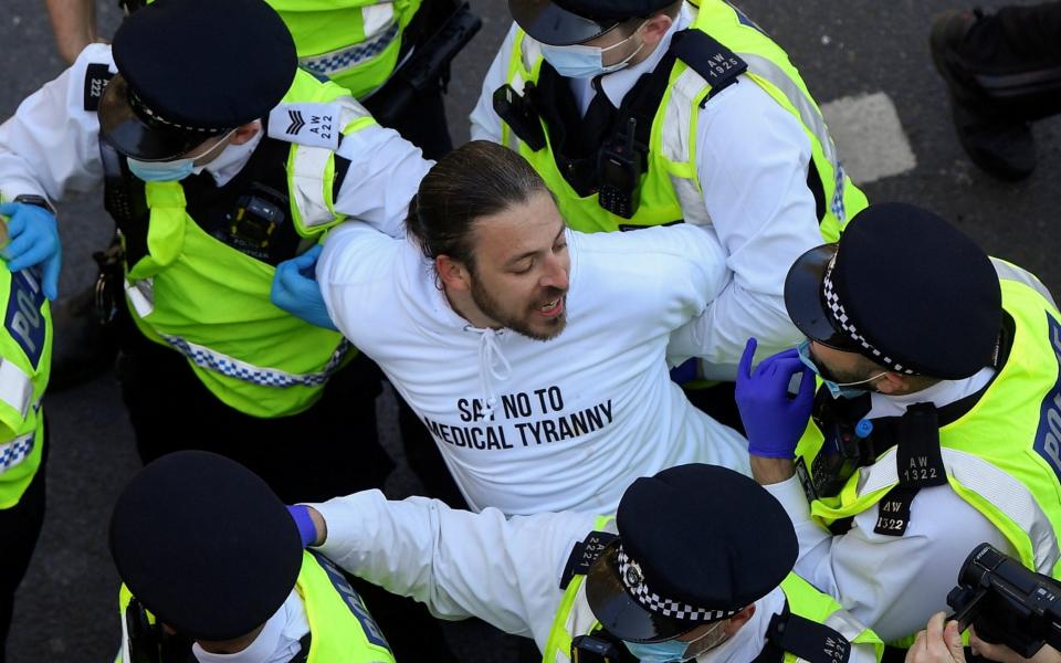 Police detain a demonstrator during an anti-lockdown protest in London - TOBY MELVILLE/REUTERS