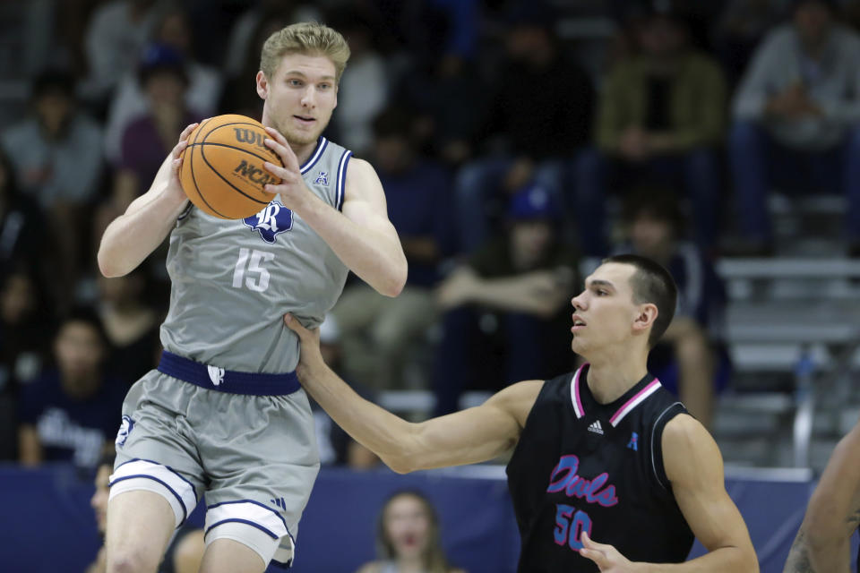 Rice forward Max Fiedler (15) pulls down a rebound in front of Florida Atlantic center Vladislav Goldin, right, during the first half of an NCAA college basketball game Wednesday, Jan. 24, 2024, in Houston. (AP Photo/Michael Wyke)