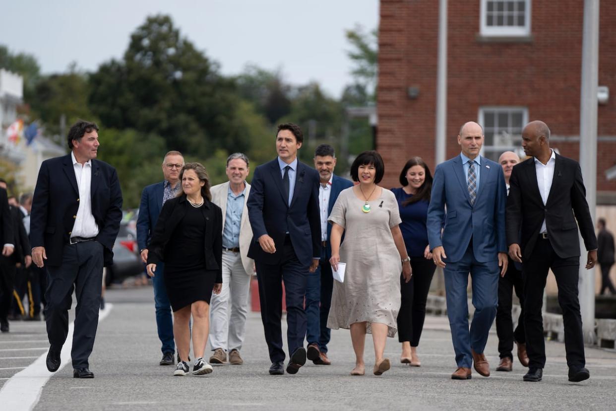 Prime Minister Justin Trudeau, centre, flanked by MPs, arrives to make an announcement during the Liberal summer caucus retreat in St. Andrews, N.B. on Tuesday, Sept. 13, 2022. (Darren Calabrese/The Canadian Press - image credit)