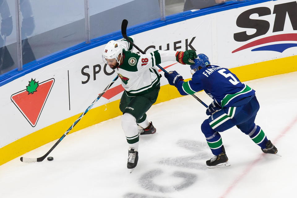 Minnesota Wild's Jordan Greenway (18) is pursued by Vancouver Canucks' Oscar Fantenberg (5) during the second period of an NHL hockey playoff game in Edmonton, Alberta, Tuesday, Aug. 4, 2020. (Codie McLachlan/The Canadian Press via AP)
