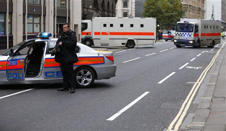 Police officers block the street while defendants under armed guard are driven into the Old Bailey in central London, December 3, 2013. REUTERS/Andrew Winning