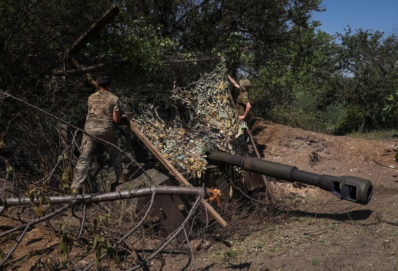 Ukrainian servicemen install a metal net over a 2S1 Gvozdika self-propelled howitzer to protect it from loitering munitions at a position near the city of Bakhmut