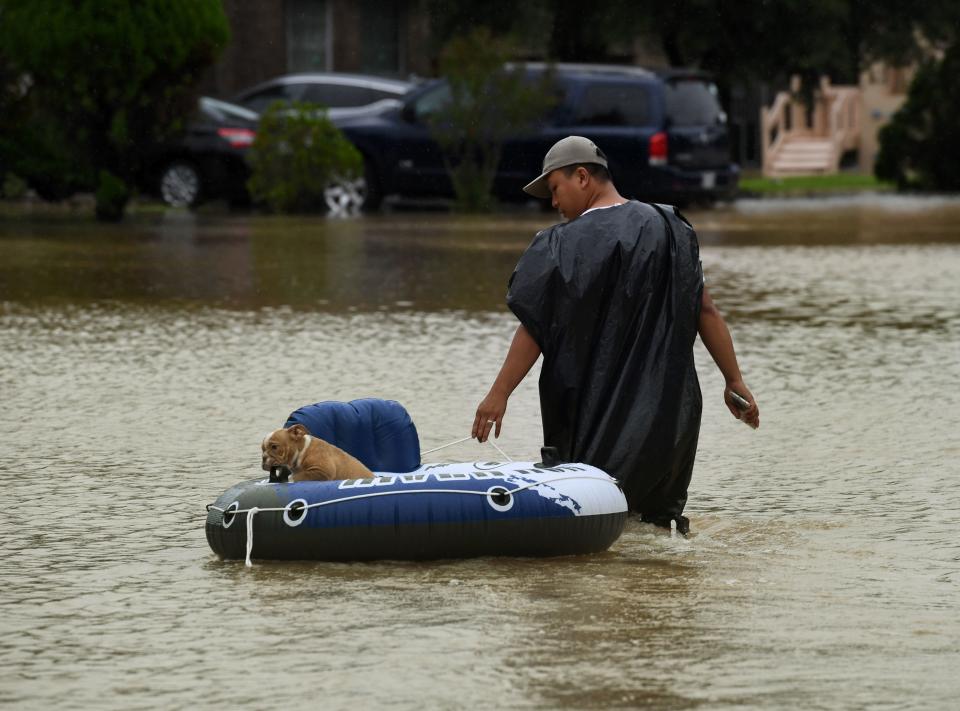 John Tuan returns to rescue his dog who was left in his flooded house in the Clodine district after Hurricane Harvey caused heavy flooding in Houston, Texas on August 29, 2017. Floodwaters have breached a levee south of the city of Houston, officials said Tuesday, urging residents to leave the area immediately. / AFP PHOTO / MARK RALSTON        (Photo credit should read MARK RALSTON/AFP/Getty Images)