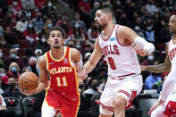 Chicago Bulls forward DeMar DeRozan, left, drives to the basket against Chicago Bulls center Nikola Vucevic during the first half of an NBA basketball game in Chicago, Wednesday, Dec. 29, 2021. (AP Photo/Nam Y. Huh)