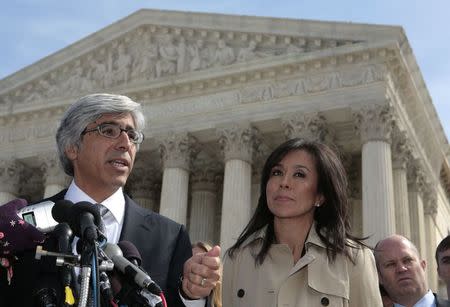 Wal-Mart's lead attorney Theodore Boutrous (L) and Wal-Mart's Executive Vice President for People Gisel Ruiz (R) speak to the media on the steps of the U.S. Supreme Court after the class action lawsuit Dukes v. Wal-Mart was argued before the Court in Washington in this March 29, 2011 file photo. REUTERS/Larry Downing/Files