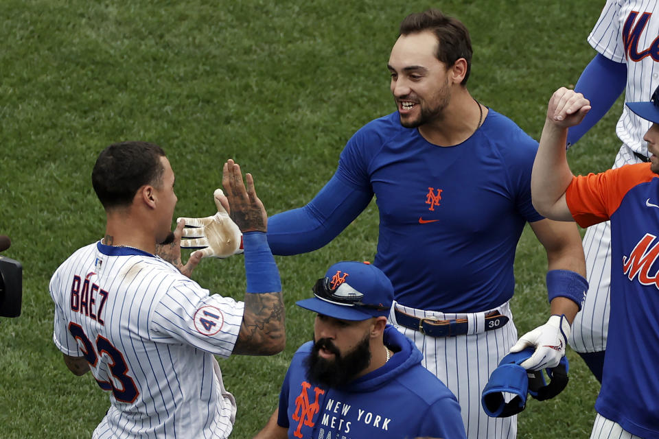 New York Mets' Michael Conforto celebrates with Javier Baez after defeating the Miami Marlins in the first game of a baseball doubleheader that started April 11 and was suspended because of rain, Tuesday, Aug. 31, 2021, in New York. The Mets won 6-5. (AP Photo/Adam Hunger)
