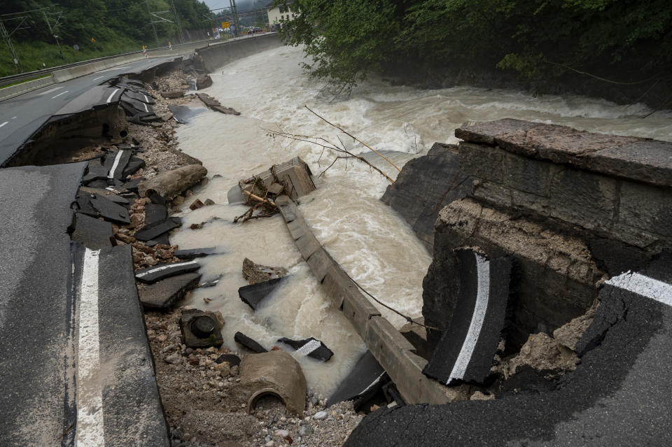 A federal road is swept away by the floodwaters in the Ramsauer Ache near Berchtesgaden, Germany Monday, July 19, 2021. About 130 people were evacuated in Germany’s Berchtesgaden area after the Ache River swelled. (Peter Kneffel/dpa via AP)