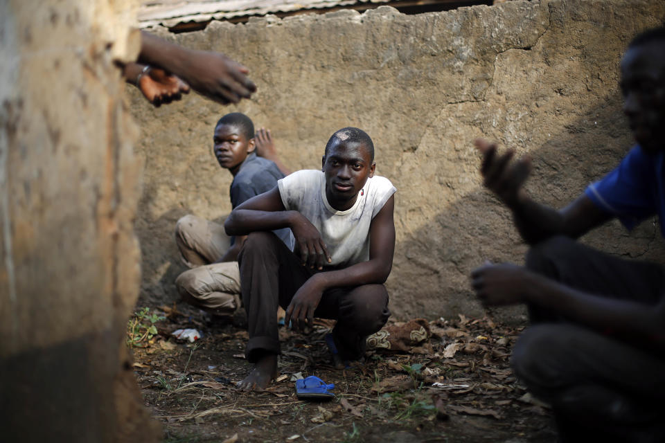 Men take cover in a toilet as heavy gunfire erupts in the Miskin district of Bangui, Central African Republic, Monday Feb. 3, 2014. In what a French soldier on the scene described as the heaviest exchange of fire he'd seen since early December 2013, Muslim militias engaged Burundi troops who returned fire. A third source of firing remained unidentified. Fighting between Muslim Seleka militias and Christian anti-Balaka factions continues as French and African Union forces struggle to contain the bloodshed. (AP Photo/Jerome Delay)