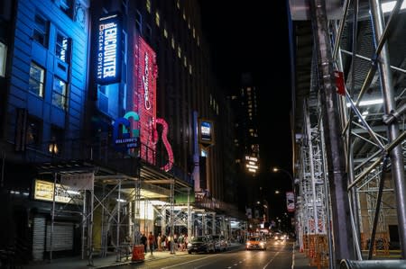 People walk near Times Square area after power was restored following a blackout that affected buildings and traffic during widespread power outages in the Manhattan borough of New York