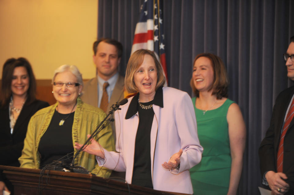 Glenna DeJong, center, and Marsha Caspar, second from left, the first gay couple married in Ingham County, hope marriage will stay legal and were on hand as the 14,756 signatures on a petition for Gov. Rick Snyder and Attorney General Bill Schuette to drop their appeal on same sex marriage were delivered in Lansing, Mich., Tuesday, March 25, 2014. (AP Photo/The Detroit News, Max Ortiz)