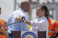 Maryland's Governor Wes Moore, left, and Transportation Secretary Pete Buttigieg shake hands during a press conference to mark the full reopening of the Port of Baltimore after the collapse of the Francis Scott Key Bridge in March, Wednesday, June 12, 2024, at the Port of Baltimore in Dundalk, Md. (AP Photo/Mark Schiefelbein)