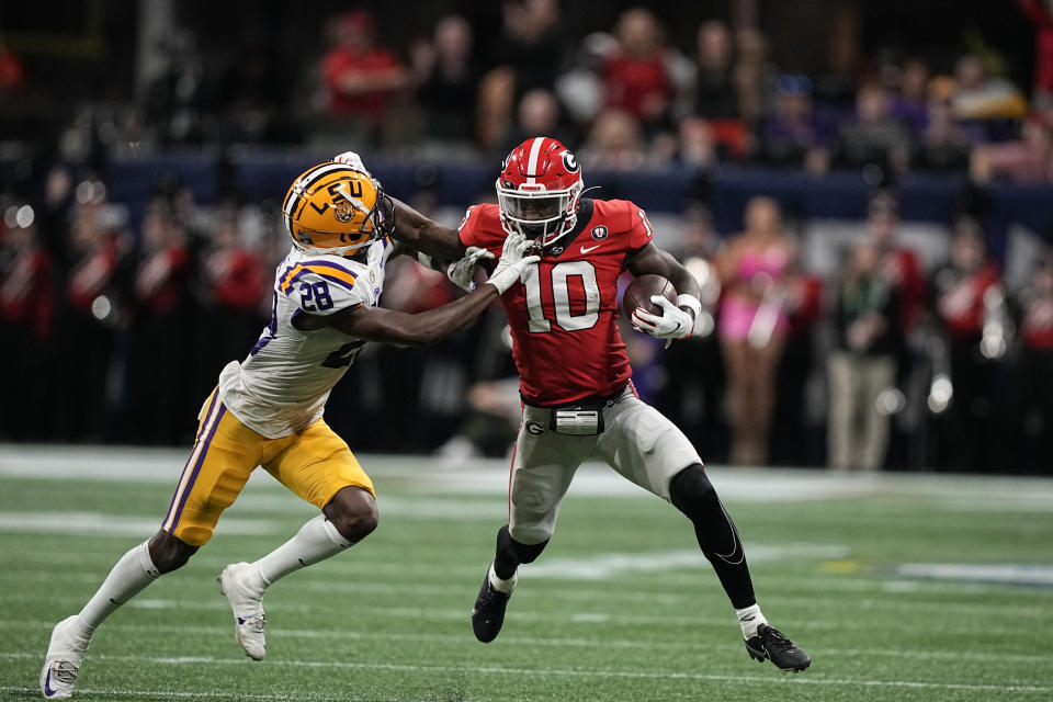 Georgia wide receiver Kearis Jackson (10) stiff arms LSU safety Major Burns (28) first half of the Southeastern Conference championship NCAA college football game, Saturday, Dec. 3, 2022, in Atlanta. (AP Photo/Brynn Anderson)