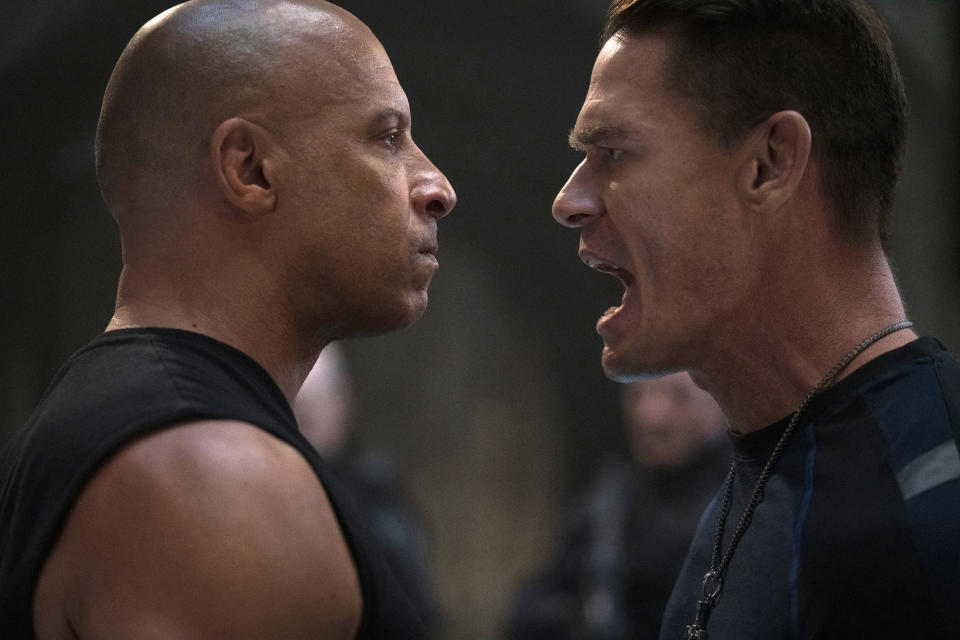 This image released by Universal Pictures shows Vin Diesel, left, and John Cena in a scene from "F9." Universal Pictures announced that the “Fast and Furious” movie titled “F9” would not open May 22 as planned but in April next year due to the coronavirus. For most people, the new coronavirus causes only mild or moderate symptoms. For some it can cause more severe illness. (Giles Keyte/Universal Pictures via AP)