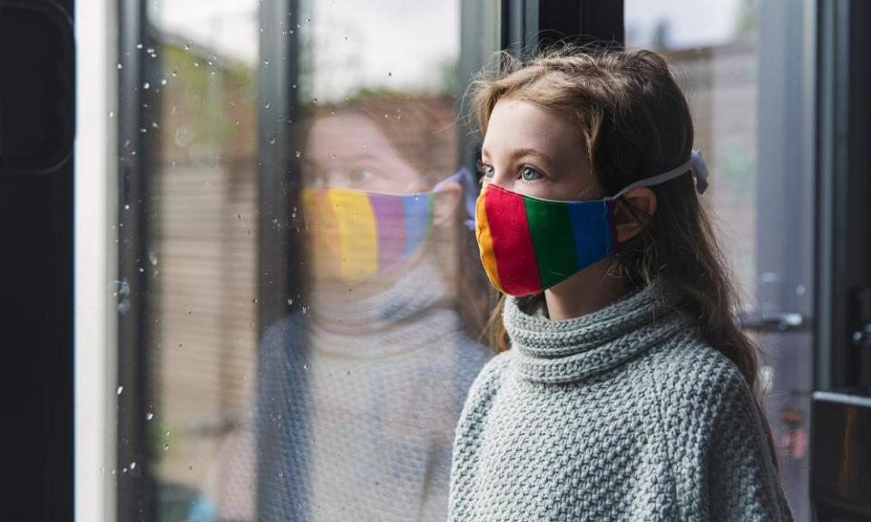 Girl in rainbow mask by window