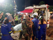 In this Sunday, June 23, 2019, photo provided by Preah Sihanouk provincial authorities, rescuers enter a victim body onto an ambulance at a site of a collapse in Preah Sihanouk province, Cambodia. Rescuers on Monday were continuing to search the rubble of a building that collapsed while under construction in a Cambodia beach town, killing dozens of workers as they slept in the unfinished condominium that was doubling as their housing. (Preah Sihanouk provincial authorities via AP)