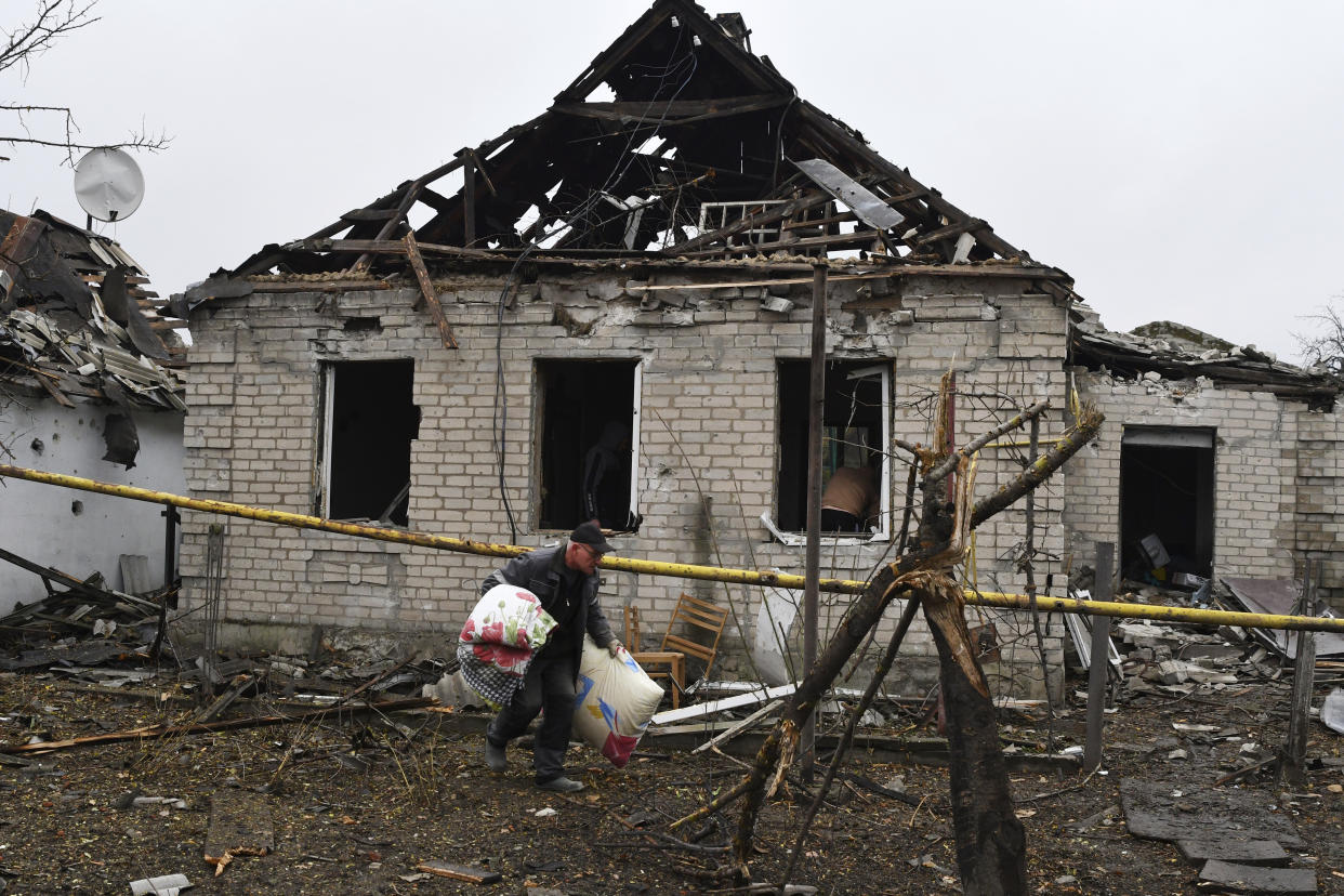 A man carries pillows from his destroyed apartment building after Russian shelling in Pokrovsk, Donetsk region, Ukraine, Friday, Nov. 4, 2022. (AP Photo/Andriy Andriyenko)