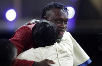 Sekou Doumbouya, of France, gets a hug after the Detroit Pistons selected him as the 15th pick overall in the NBA basketball draft Thursday, June 20, 2019, in New York. (AP Photo/Julio Cortez)