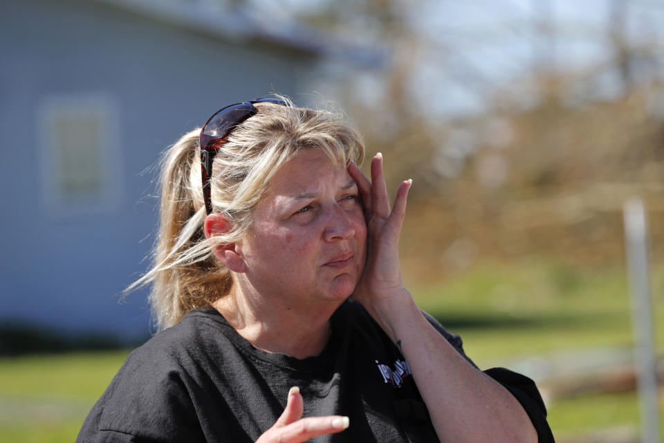 In this Oct. 13, 2018 photo, Pam Rudd reacts as she helps her mother-in-law remove possessions from her damaged home in the aftermath of Hurricane Michael in Panama City, Fla. “We’re lucky that we at least have a place to stay,” Rudd said. “There are people walking up and down the road with backpacks and no place to go.” (AP Photo/Gerald Herbert)