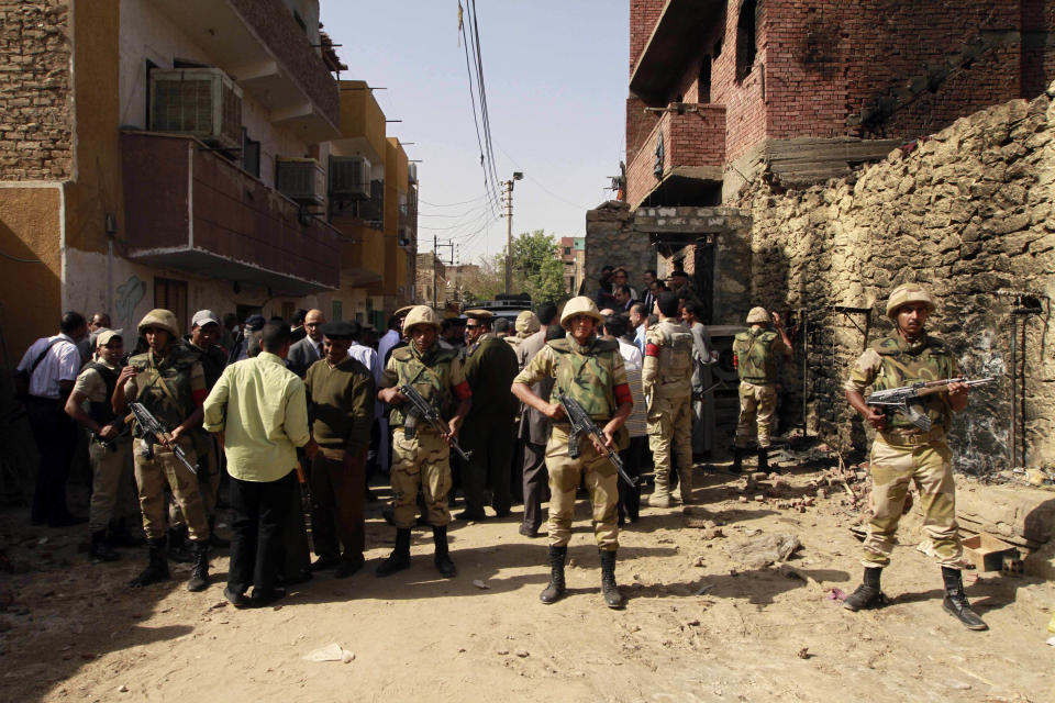 Egyptian security forces stand guard as Egyptian prosecutor general, Hisham Barakat, tours the area where fighting took place on Friday, April 4, between a Nubian family and members of the Arab Haleyla clan, in the southern city of Aswan, Egypt, Tuesday, April 8, 2014. Telephone and internet networks were briefly shut down to Egypt’s southern province of Aswan for several hours, as authorities moved to try to end a bloody tribal feud that killed tens the past week, security officials and residents said Tuesday. (AP Photo/Sabry Khaled, El Shorouk Newspaper) EGYPT OUT