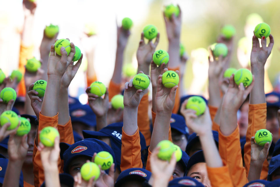 Australian ball kids hold up Australian Open tennis balls.