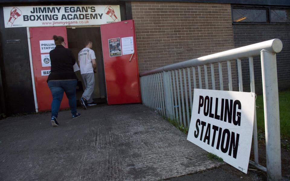 Voters arrive at a polling station in Manchester on Thursday - Credit: Oli Scarff/AFP