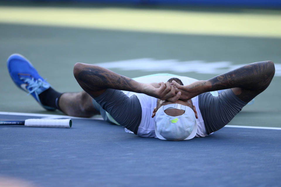 Nick Kyrgios, of Australia, lies on the court after he defeated Yoshihito Nishioka, of Japan, during a final at the Citi Open tennis tournament Sunday, Aug. 7, 2022, in Washington. Kyrgios won 6-4, 6-3.(AP Photo/Nick Wass)