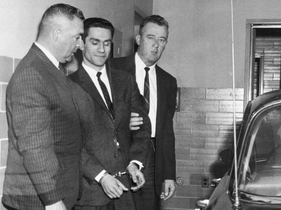 George Nassar seen wearing handcuffs arriving at court accompanied by law enforcement in 1964.