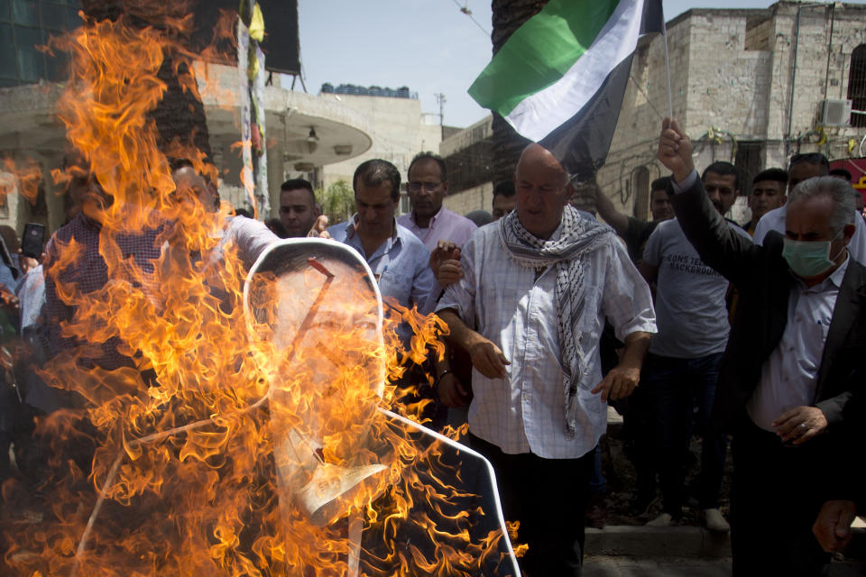 Palestinians burn a cutout of the U.S. Secretary of State Mike Pompeo, during a protest against his visit to Israel and U.S. President Donald Trump's Mideast initiative, in the West Bank city of Nablus, Thursday, May 23, 2020.(AP Photo/Majdi Mohammed)
