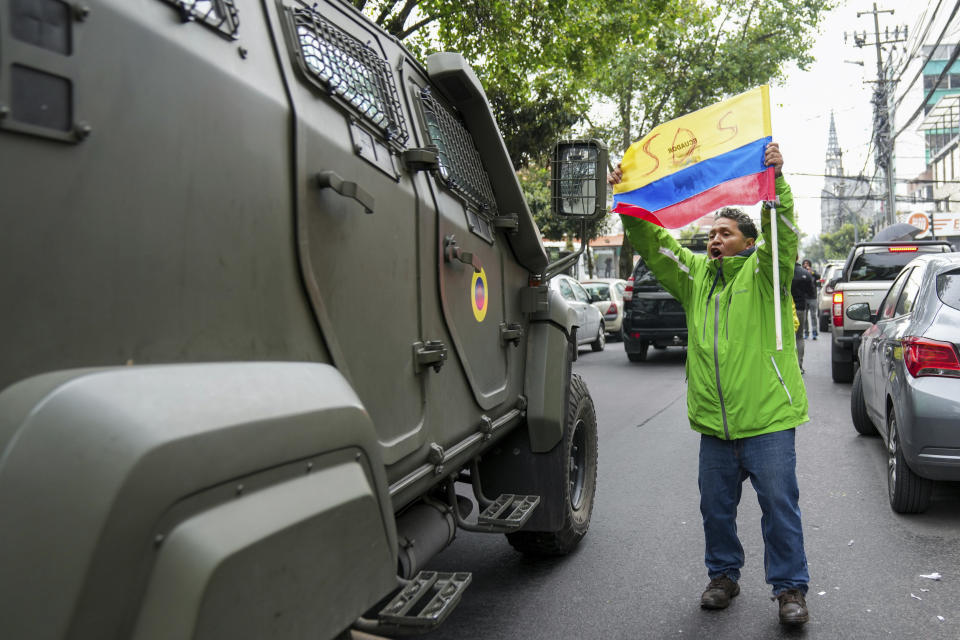 Un partidario del exvicepresidente ecuatoriano Jorge Glas protesta mientras un vehículo militar lo transporta desde el centro de detención en el que estuvo detenido tras su arresto en la embajada de México en Quito, Ecuador, el sábado 6 de abril de 2024. Glas, quien ocupó la vicepresidencia de Ecuador entre 2013 y 2018, fue condenado por corrupción y se encontraba refugiado en la embajada desde diciembre. (Foto AP/Dolores Ochoa)