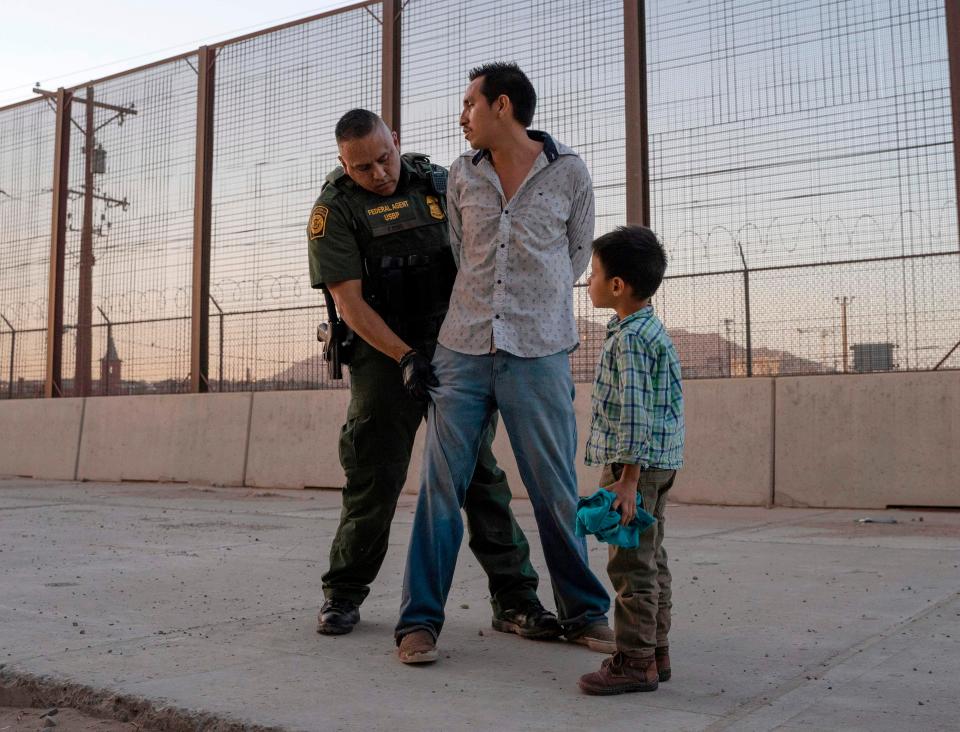 In this file photo taken on May 16, 2019, José, 27, with his son José Daniel, 6, is searched by U.S. Customs and Border Protection Agent Frank Pino in El Paso.
