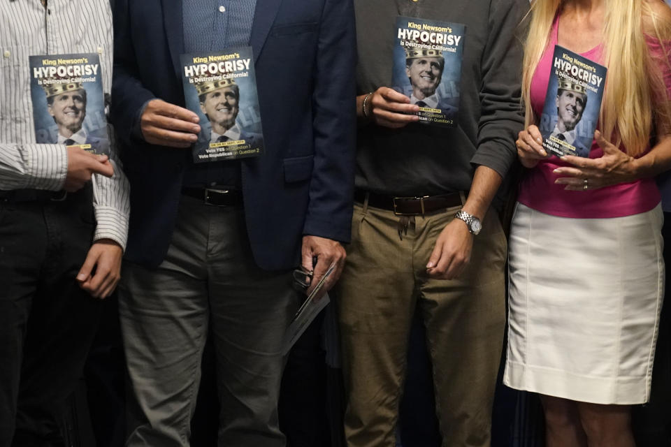 Supporters of the effort to recall California Governor Gavin Newsom hold pamphlets at the San Diego Republican Party Headquarters, Monday, Sept. 13, 2021, in San Diego. Voting concludes Tuesday in California's recall election. (AP Photo/Gregory Bull)