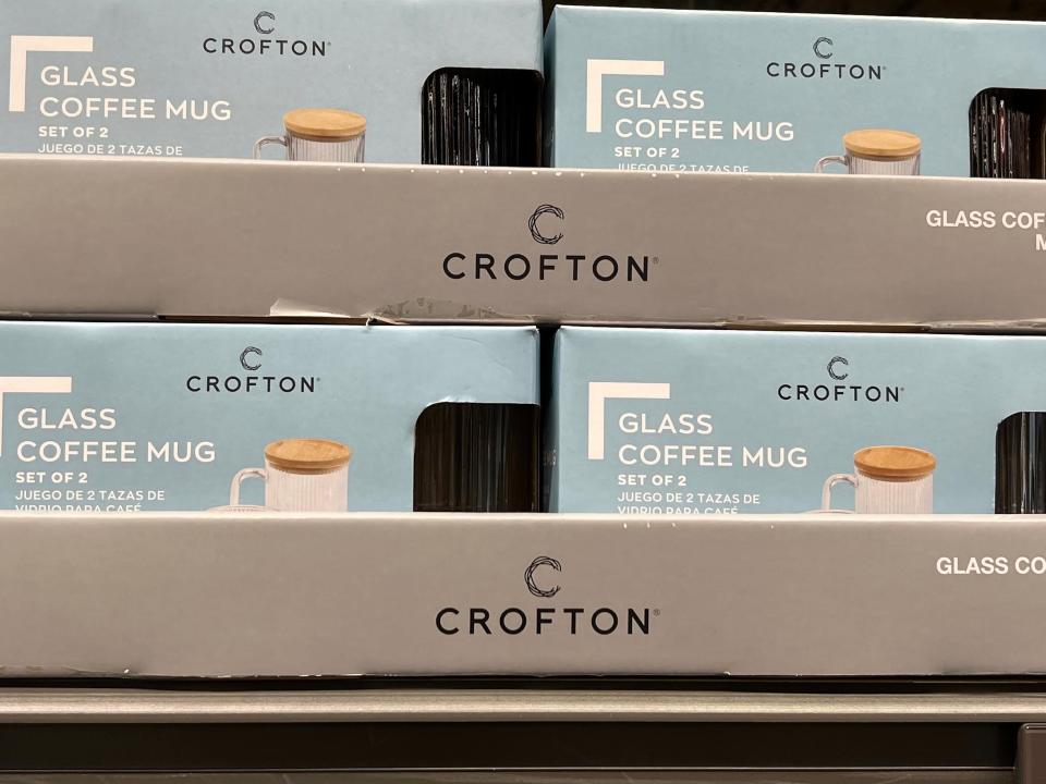 Gray cardboard boxes with Crofton label holding blue boxes of Crofton glass coffee mugs. Pictures of mugs are on the boxes