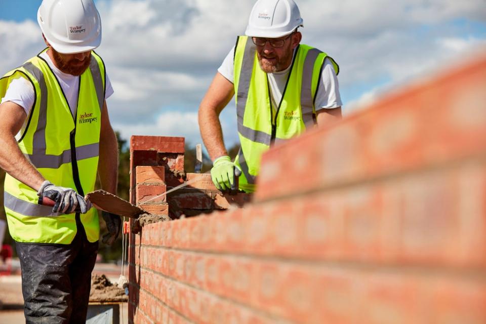 Workers laying bricks at a construction site  (PA Media)