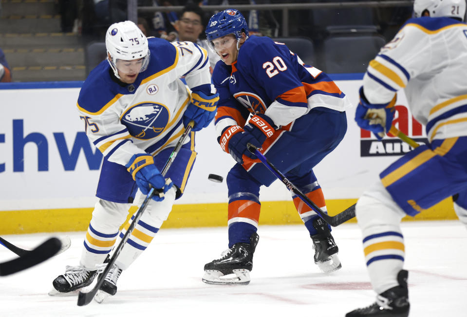 Buffalo Sabres defenseman Connor Clifton (75) and New York Islanders right wing Hudson Fasching (20) battles for the puck during the second period of an NHL hockey game, Saturday, Oct. 14, 2023, in New York. (AP Photo/Noah K. Murray)