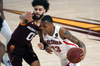 Arizona guard James Akinjo (13) drives on Arizona State guard Holland Woods during the second half of an NCAA college basketball game, Thursday, Jan. 21, 2021, in Tempe, Ariz. Arizona won 84-82. (AP Photo/Rick Scuteri)