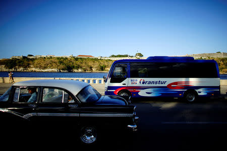 A vintage car passes by a Chinese-made Yutong bus parked at the sea front Malecon in Havana, Cuba, February 6, 2017. REUTERS/Alexandre Meneghini