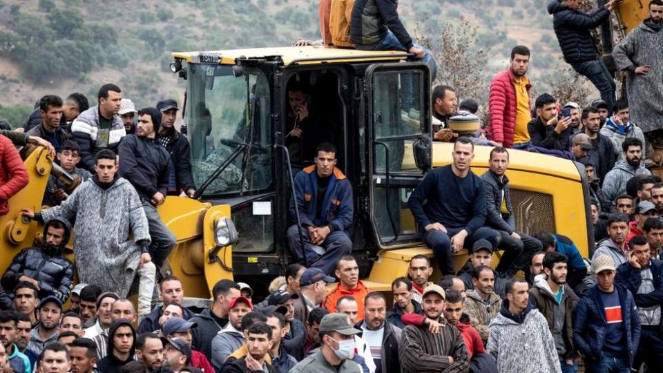 Gente observa cómo los equipos de los servicios de emergencia marroquíes trabajan en el rescate de Rayan, un niño de cinco años, de un pozo en el que cayó.