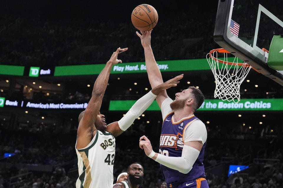 Phoenix Suns center Jusuf Nurkic (20) blocks a shot by Boston Celtics center Al Horford (42) during the first half of an NBA basketball game, Thursday, March 14, 2024, in Boston. (AP Photo/Charles Krupa)