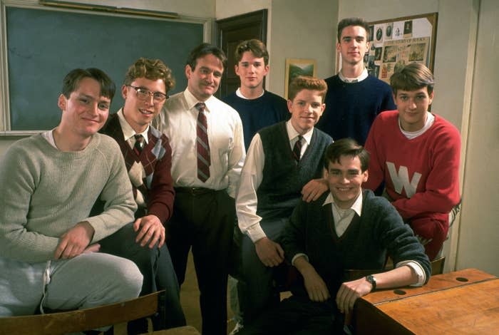 Ethan stands next to Robin in a classroom with other students on the film's set