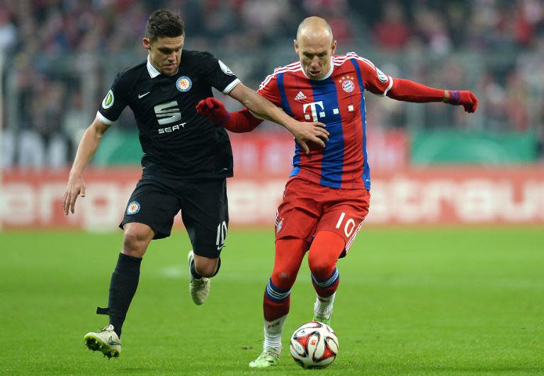 Braunschweig's midfielder Mirko Boland (L) and Bayern Munich's Dutch midfielder Arjen Robben vie for the ball during their German football Cup DFB Pokal round of 16 match in Munich, Germany on March 4, 2015