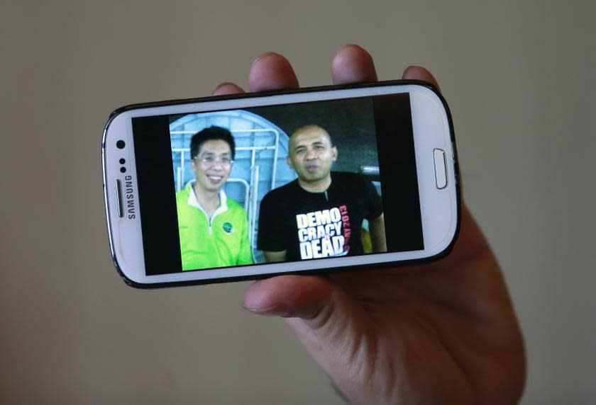 Peter Chong holds up his smartphone to show a photo of himself with missing Malaysia Airlines Flight MH370 captain Zaharie Ahmad Shah at a hotel in Sepang March 18, 2014. — Reuters pic
