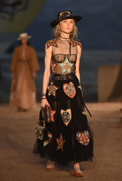 <p>A model in an embroidered dress and bolero hat walks the runway during the first cruise collection by Maria Grazia Chiuri for Dior show in Calabasas, Calif. (Photo: Getty Images) </p>