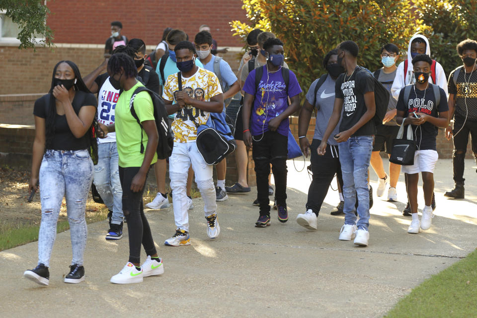 Students walk across campus Monday, August 17, 2020, as Tupelo High School began it's new school year after a three day delay in Tupelo Mississippi. (Thomas Wells/Northeast Mississippi Daily Journal via AP)