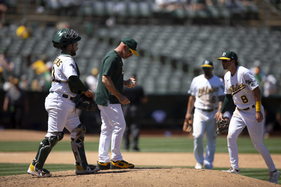 Oakland Athletics manager Mark Kotsay, center, confers with his infielders during a pitching change against the Chicago White Sox during the sixth inning of a baseball game, Sunday, July 2, 2023, in Oakland, Calif. (AP Photo/D. Ross Cameron)