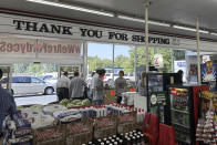 Employees work the checkout lines of the Mad Butcher grocery store in Fordyce, Arkansas on Tuesday, July 2, 2024. The grocery store reopened on Tuesday, 11 days after a shooter killed four people and injured 10 others in in the store and its parking lot. (AP Photo/Andrew DeMillo)