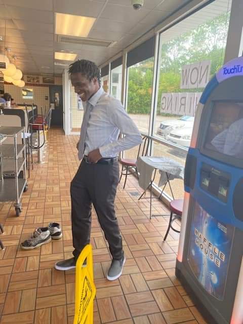 Timothy Harrison smiles in the new outfit his Waffle House co-workers bought him for his high school graduation ceremony.