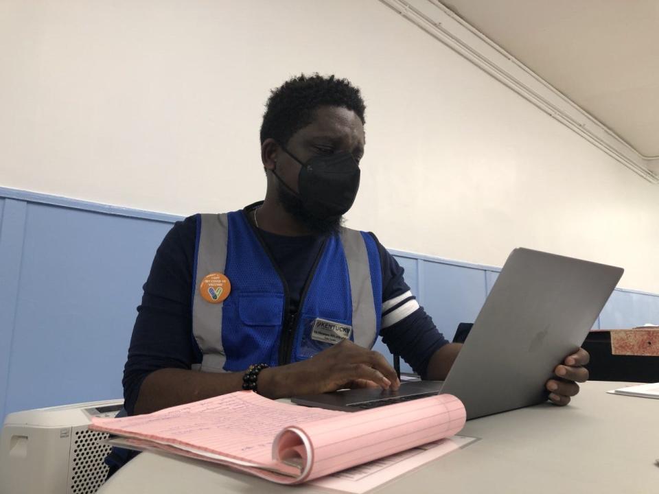 Oluwasegun Abe does paperwork on his laptop while waiting on patients at a LouVax clinic at Shawnee Community Center on Thursday,  Jan. 13, 2022.