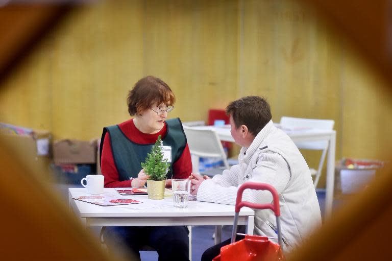 File picture shows a volunteer (L) speaking to a visitor at a foodbank charity in west London