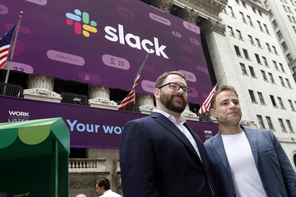 Slack co-founders Cal Henderson, left, and Stewart Butterfield pose for photos outside the New York Stock Exchange before their company's IPO, Thursday, June 20, 2019. (AP Photo/Richard Drew)