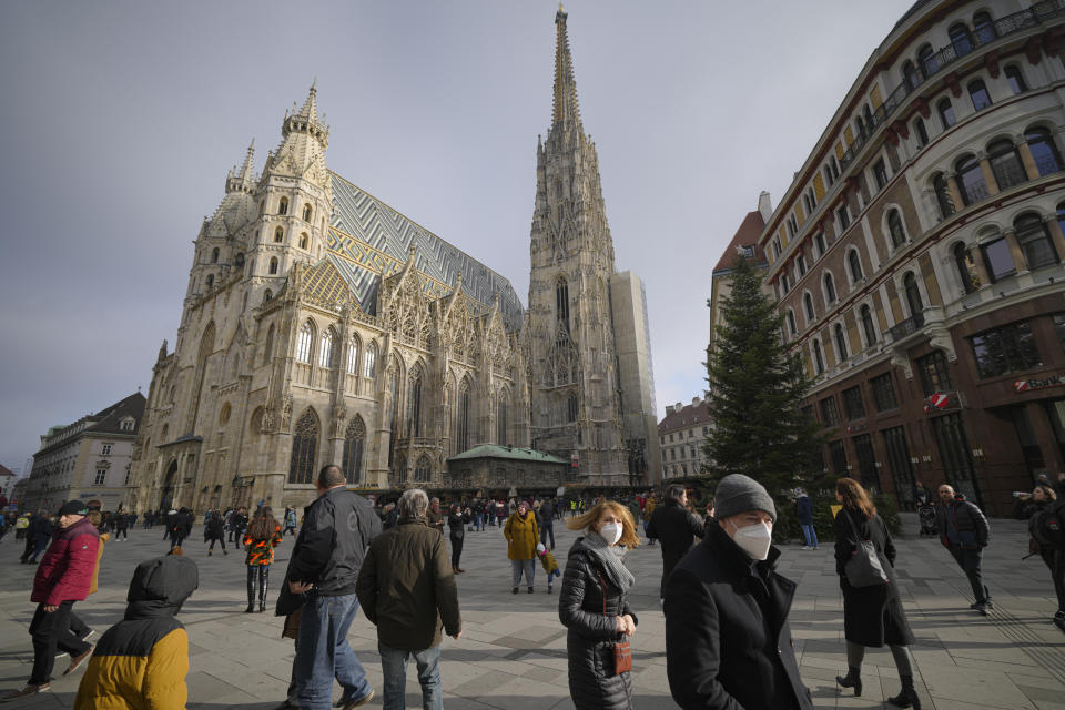 People walk by the St. Stephen's Cathedral in Vienna, Austria, Sunday, Nov. 21, 2021. The Austrian government announced a nationwide lockdown that will start Monday and comes as average daily deaths have tripled in recent weeks and hospitals in heavily hit states have warned that intensive care units are reaching capacity.(AP Photo/Vadim Ghirda)